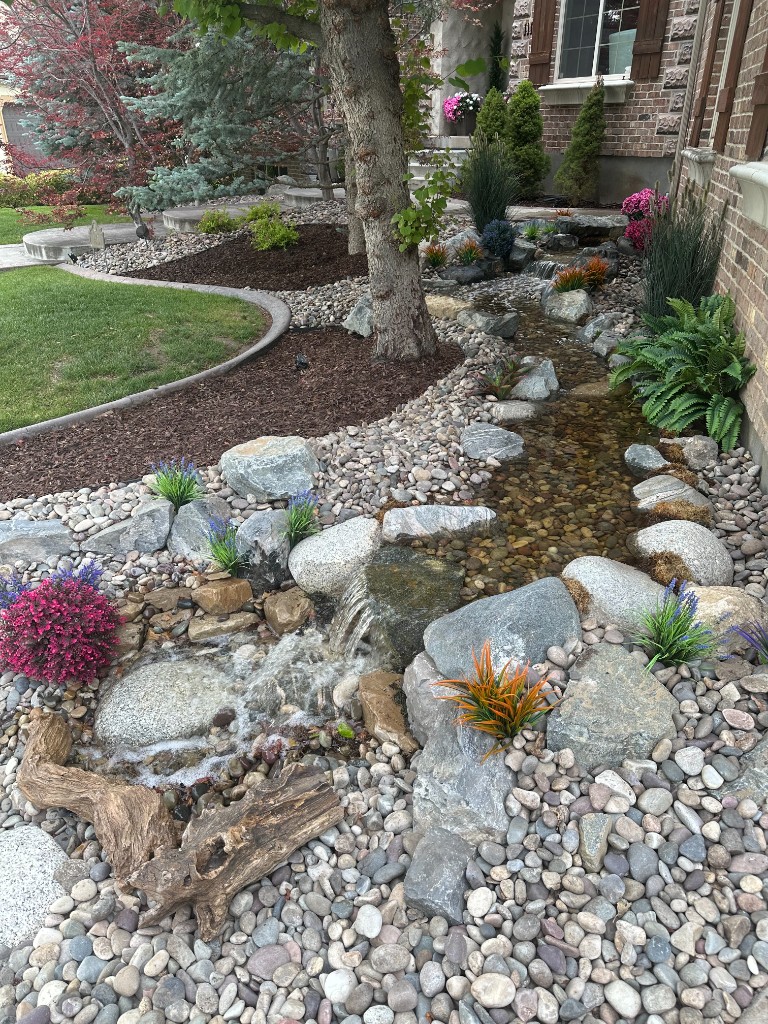 Front-yard pondless stream integrated beside a home