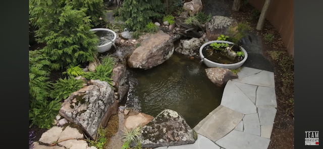 Overhead view of a pond with two overflowing stone basins and a flagstone path